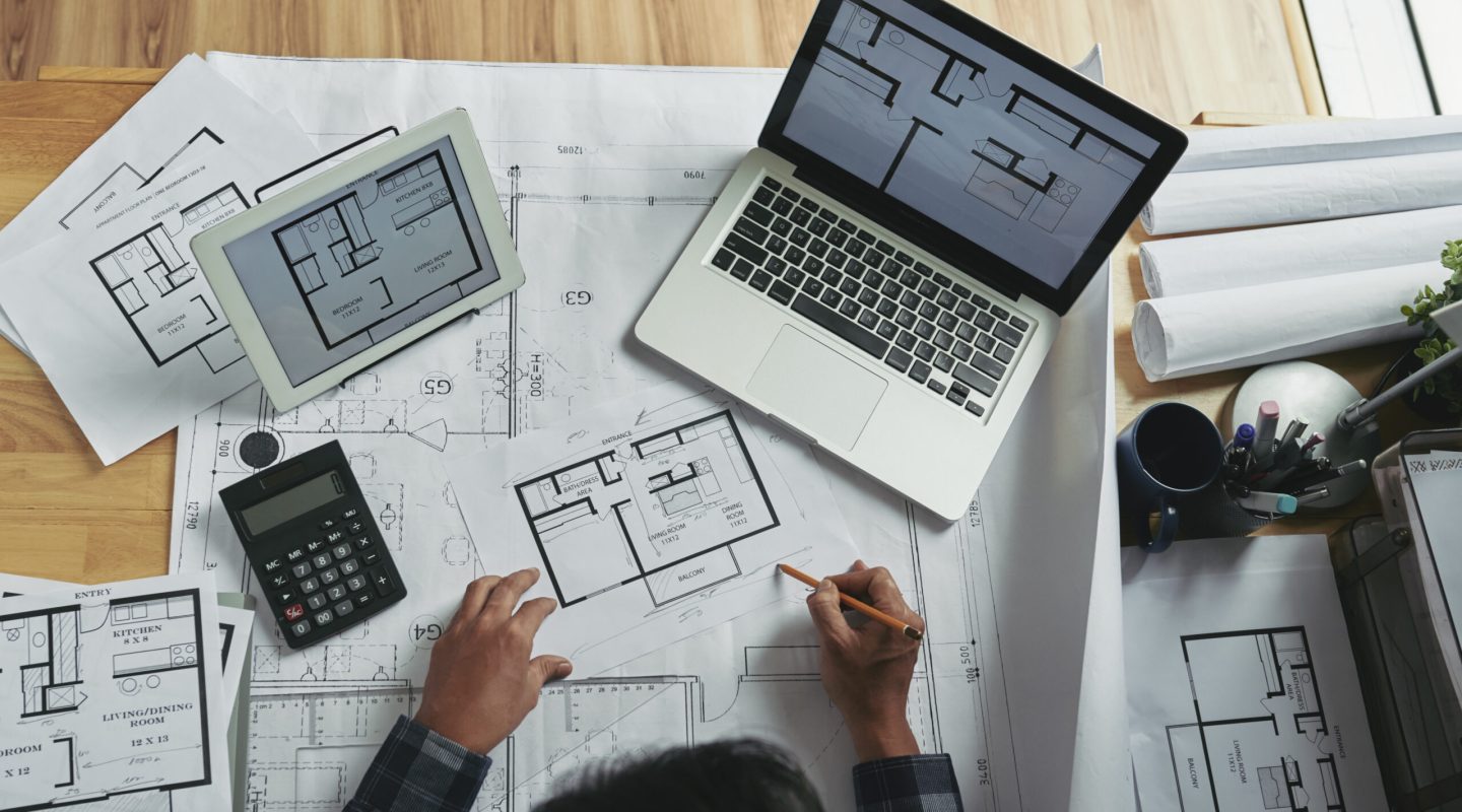 Professional architect making corrections in apartment blueprint, view from above